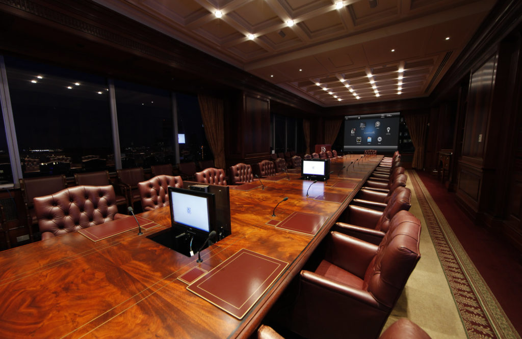 Executive conference room with leather chairs, recessed lighting and pop-up displays
