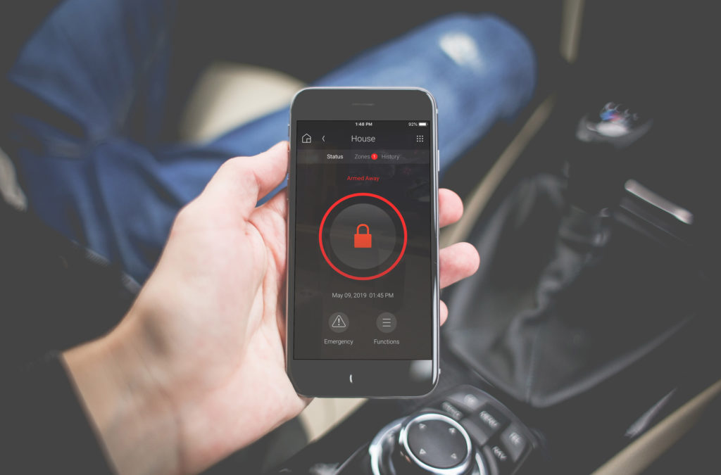 Hand holding a phone with a security system lock screen
