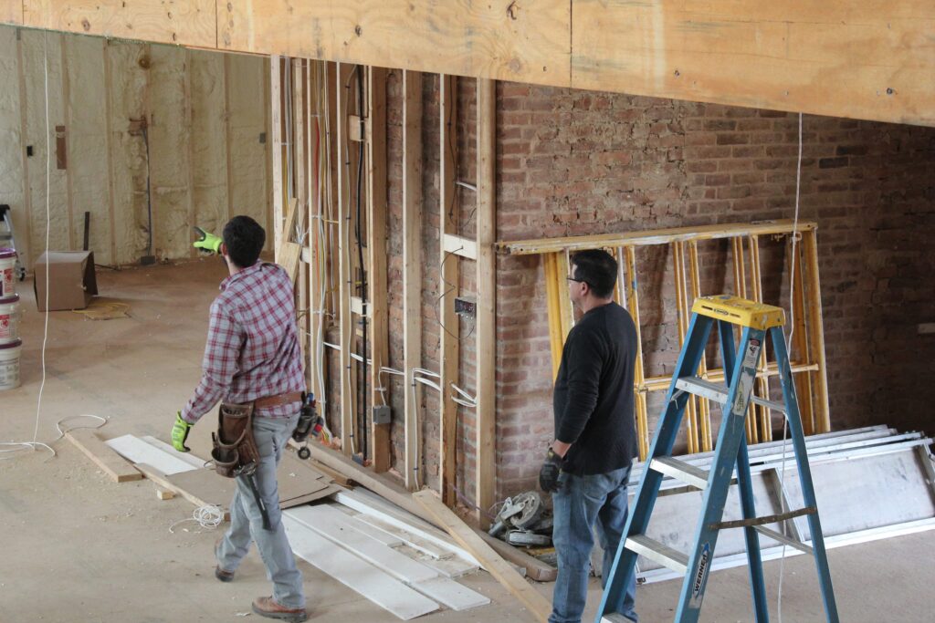 Our crew planning the wiring in a gutted renovation with exposed brick